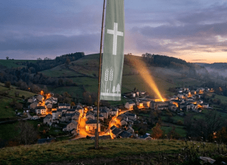 Banner reading 'Harvest Festival Welcome' with a village lit up at dusk in the background